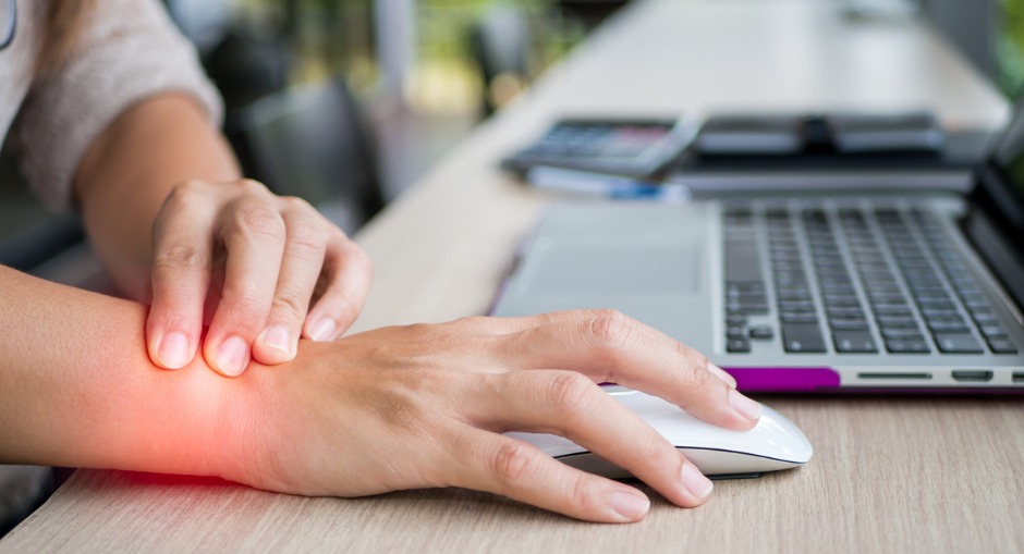 Woman holding her wrist in pain from either carpal tunnel or RSI