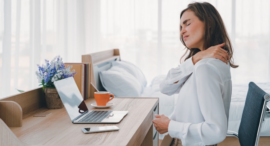 Woman suffering with neck pain from bad desk posture. 