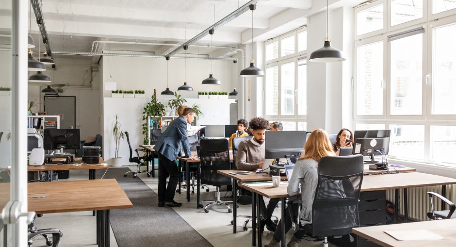 Office workers sitting at their workstations while undergoing an ergonomic assessment.