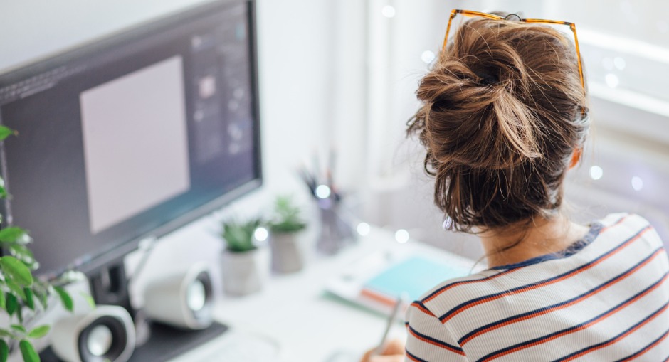 A young female office worker working from home with the right ergonomic essential equipment. 