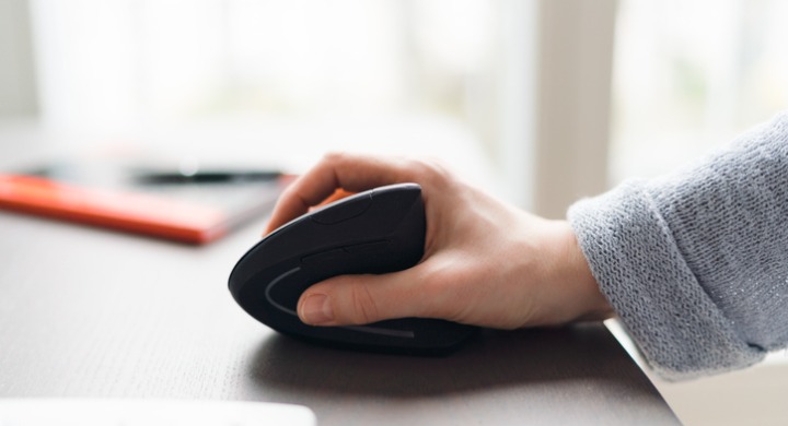 Woman uses an ergonomic mouse and keyboard while working from home.