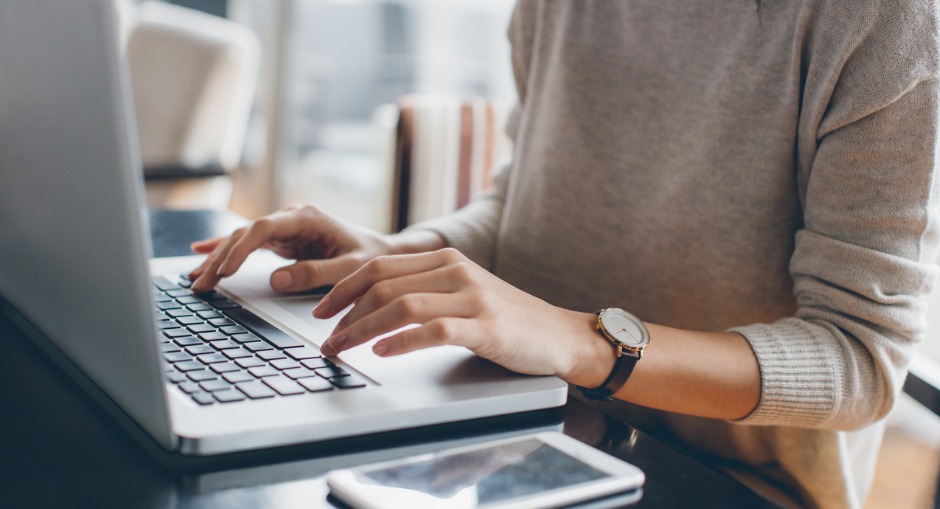 Young female office worker typing with good posture