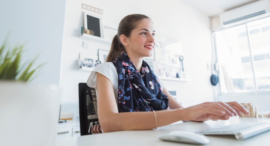 a professional woman sitting at her desk typing on her keyboard